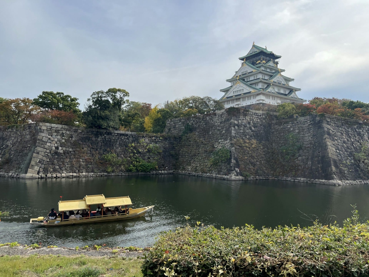 Parit dan dinding batu Kastil Osaka dengan perahu di atas air