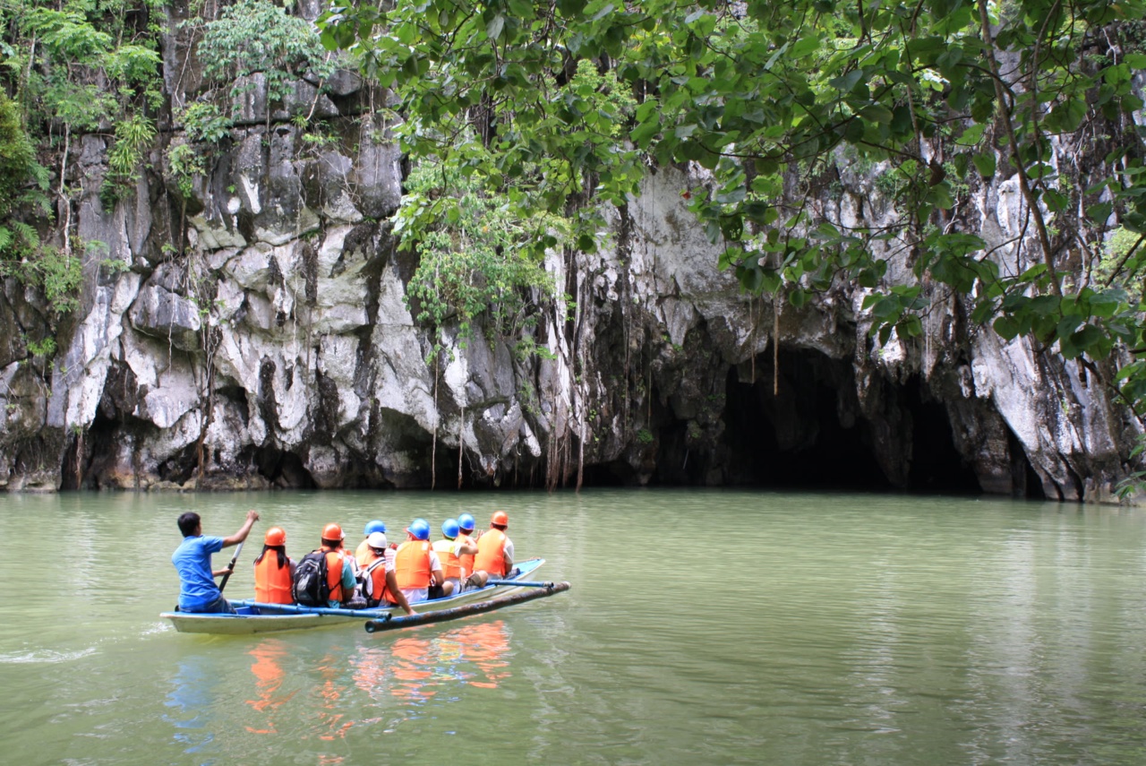 L'entrée de la grotte de la rivière souterraine avec un bateau devant