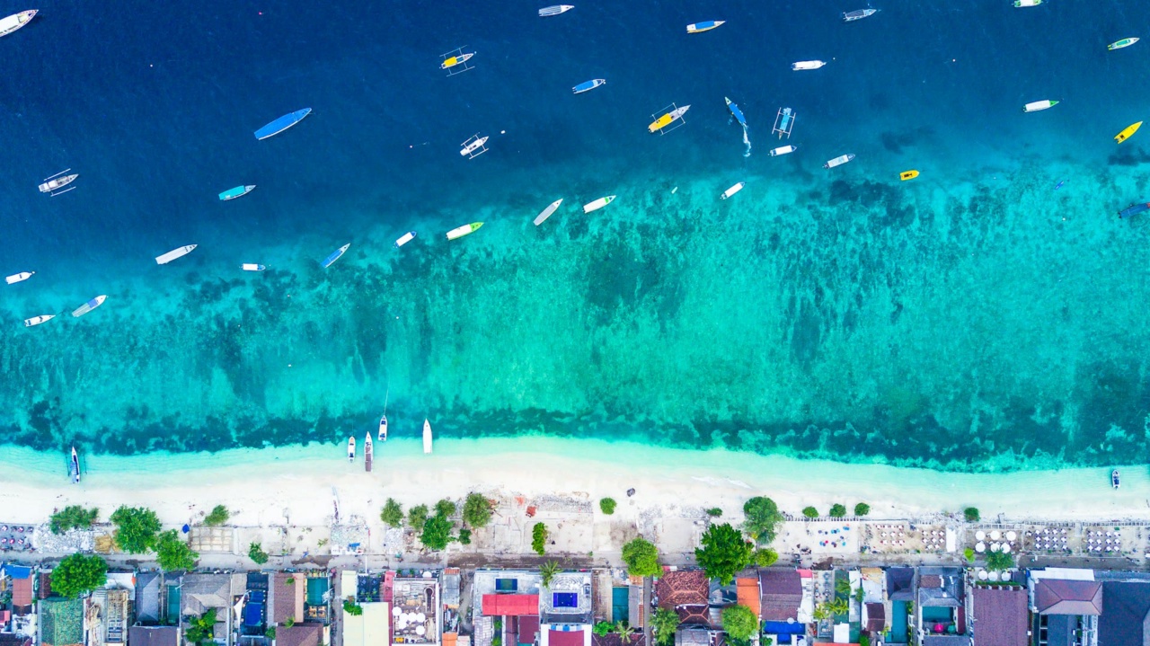 ギリ・トラワンガンのビーチを空から見た写真。ターコイズブルーの海に船が浮かんでいる