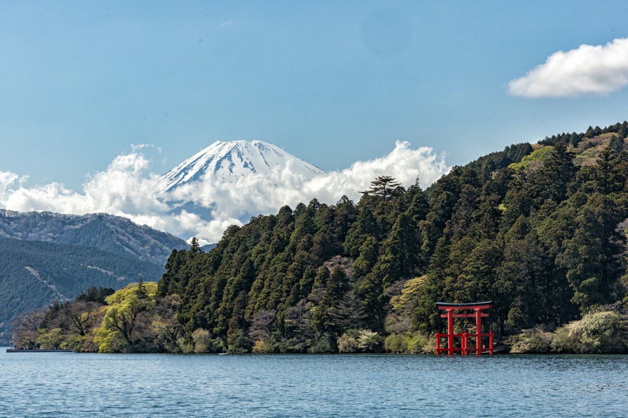 Blick über einen See in Hakone mit rotem Torii und dem Fuji im Hintergrund