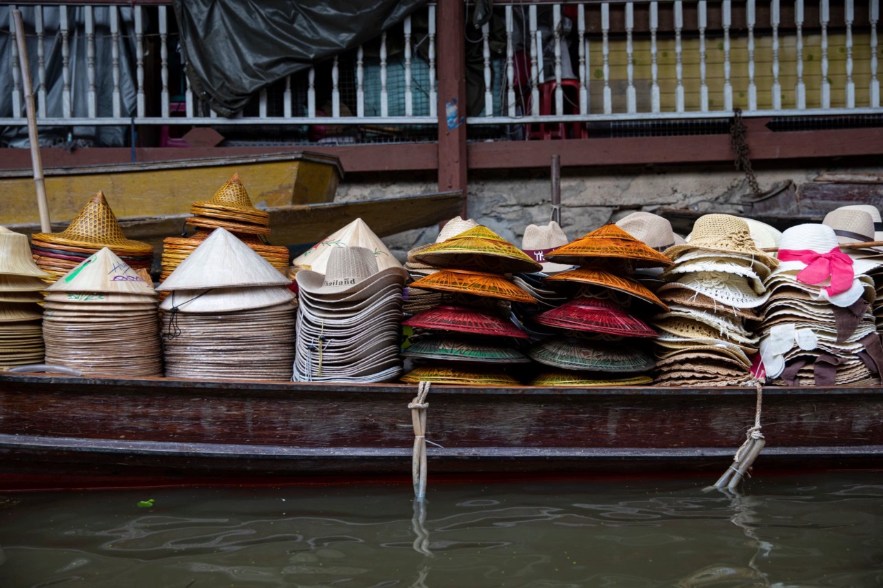 Topi anyaman bertumpuk di atas perahu di pasar terapung