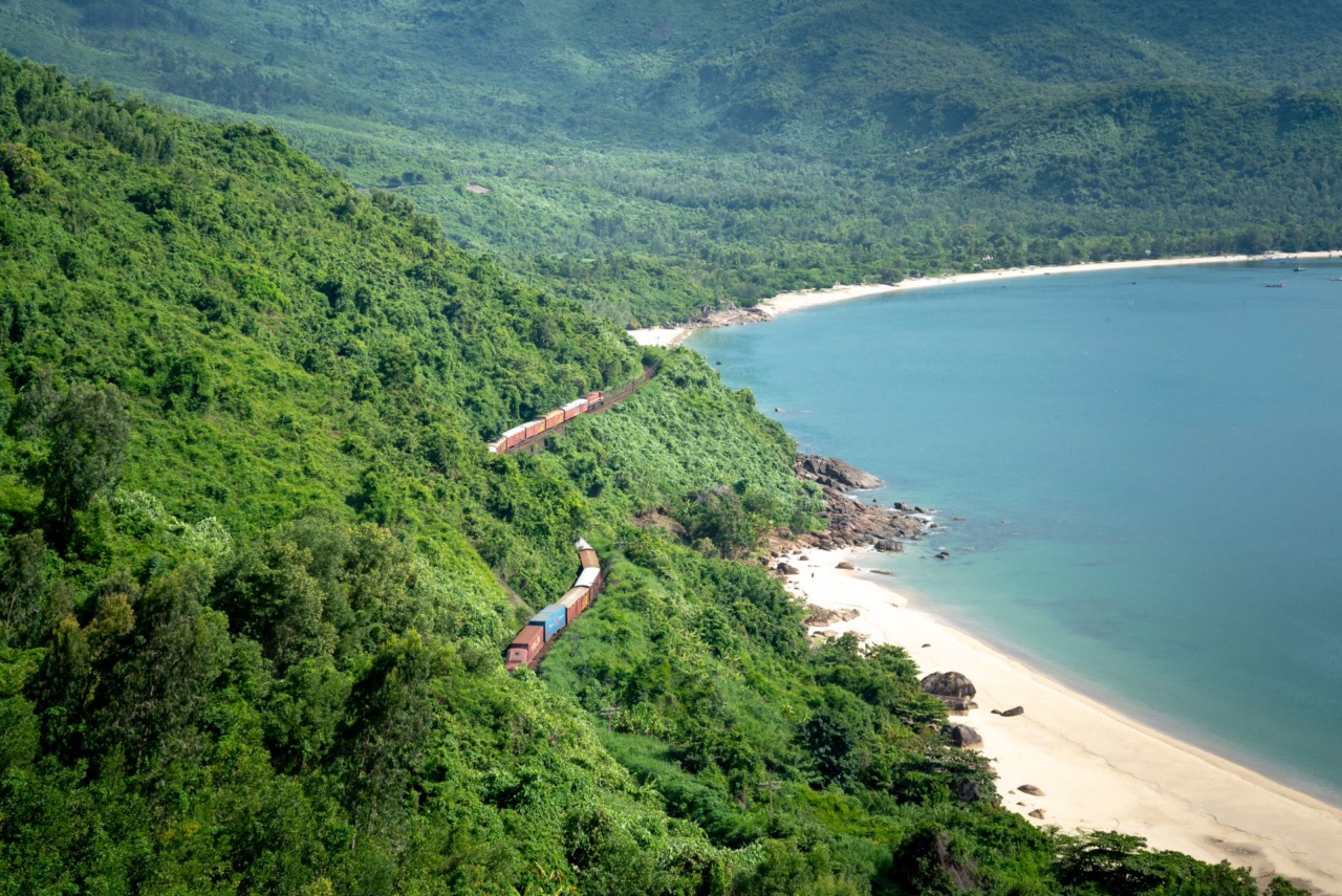 A train on a railway between green hills and the sea in Vietnam