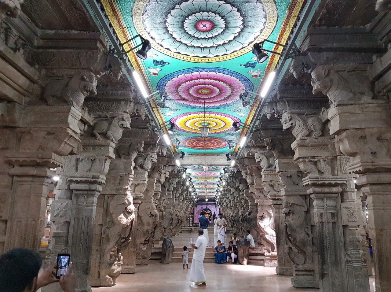Ein Gang mit geschnitzten Säulen und bemalter Decke im Meenakshi-Tempel