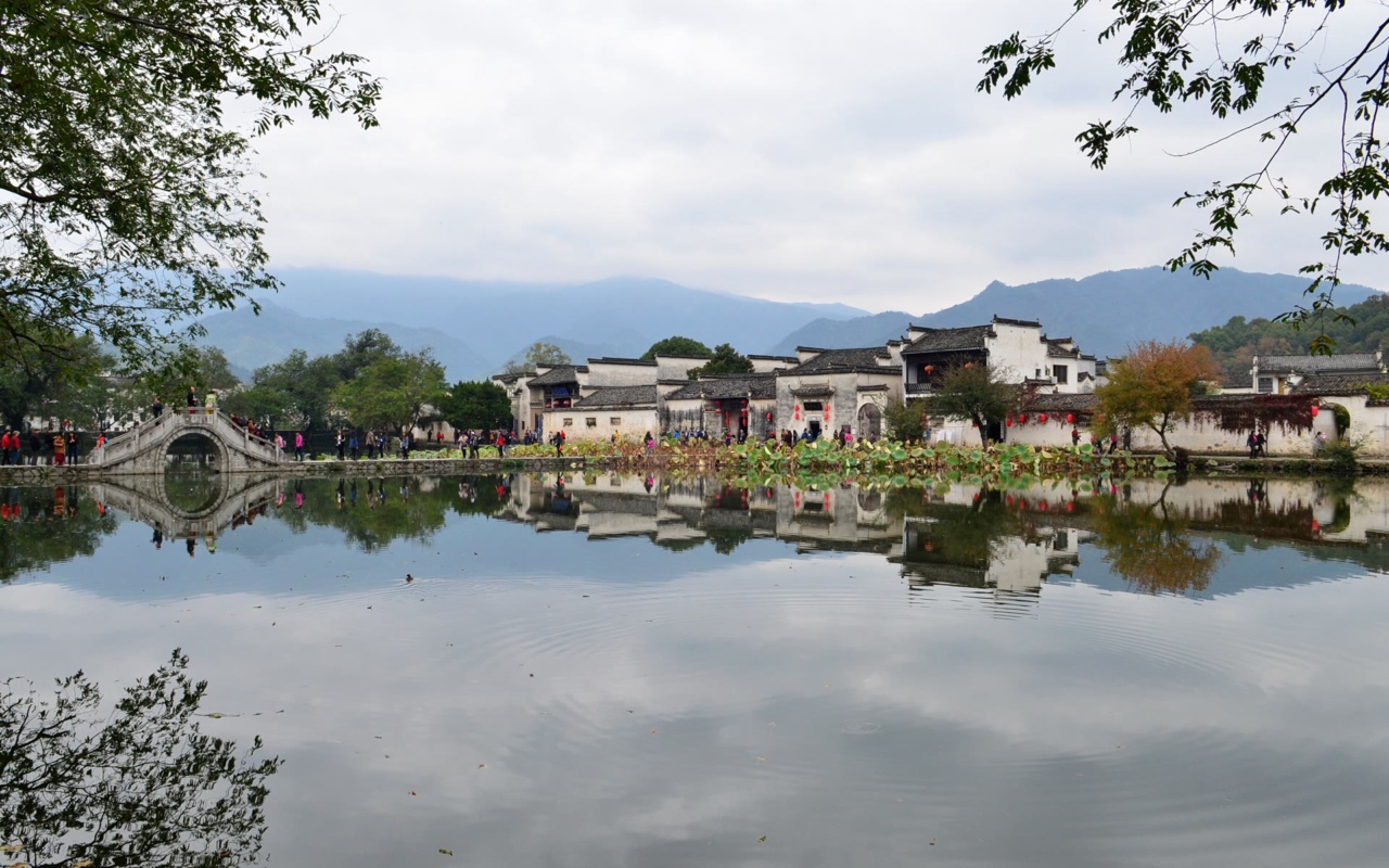 Tasik Selatan di Hongcun dengan jambatan gerbang batu dan rumah di tepi tasik