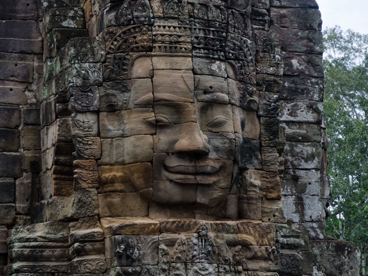 A smiling stone face on one of Bayon's towers