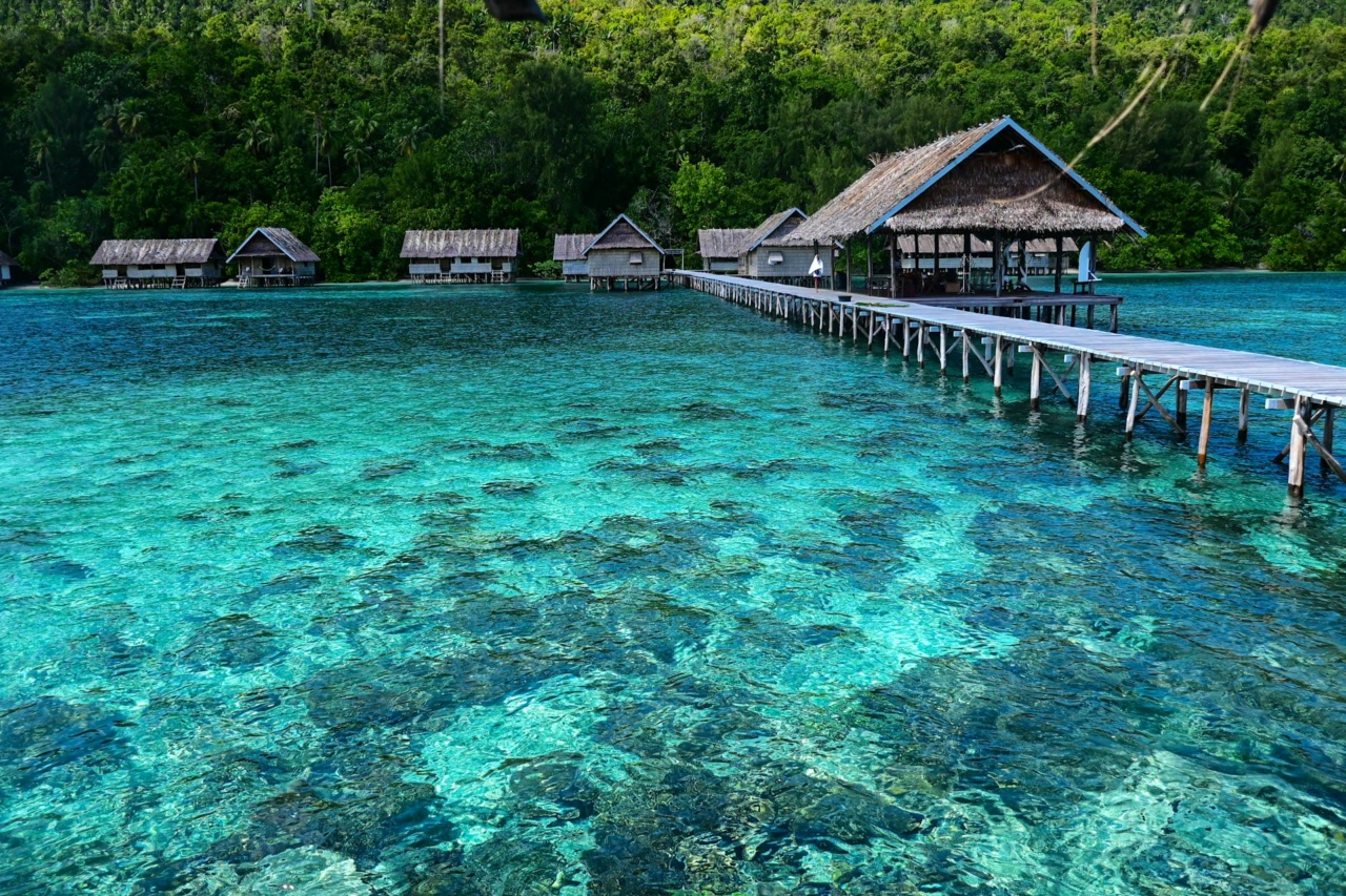 Ein Holzsteg zu einer Tropeninsel in Raja Ampat