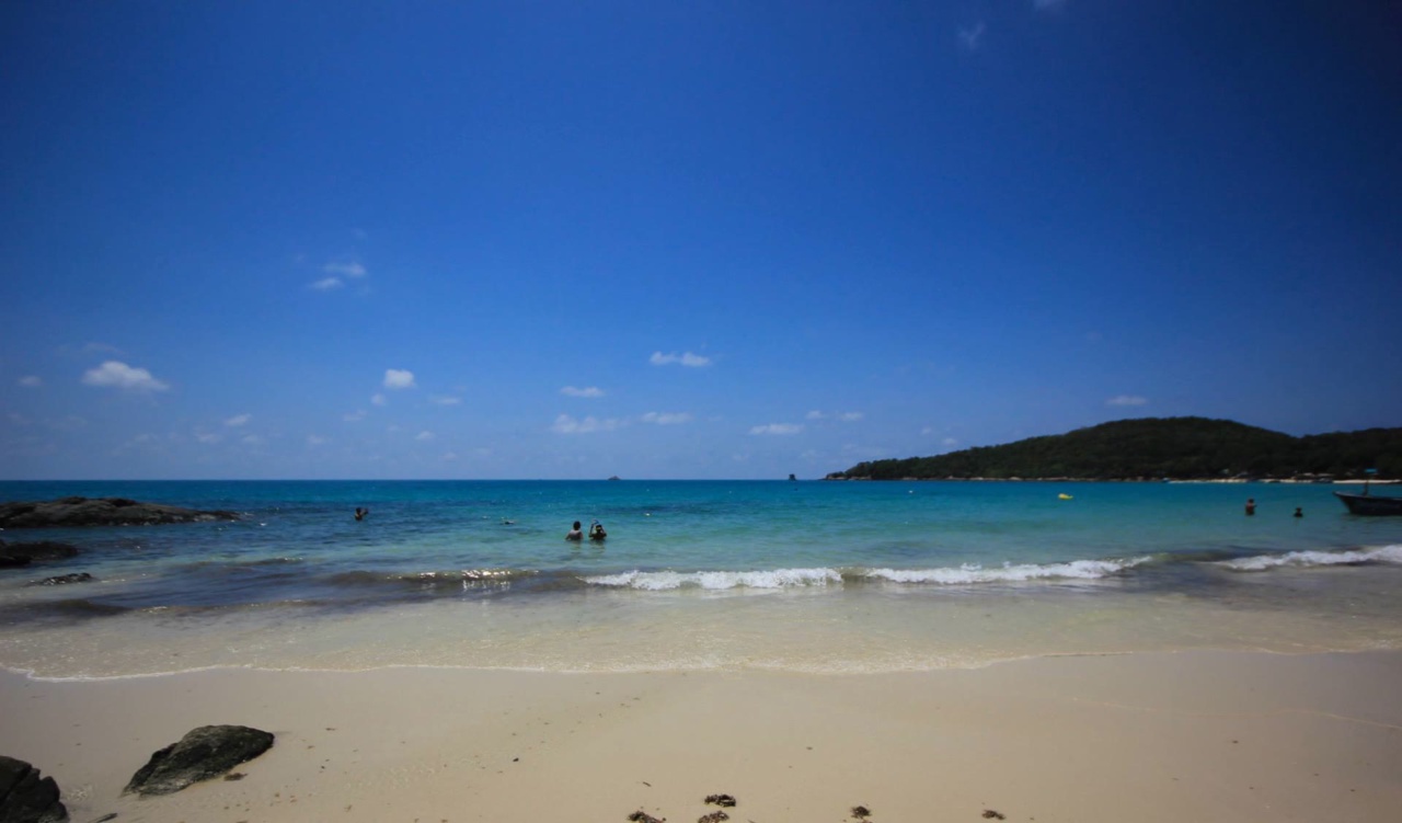 Plage de sable, eau turquoise et cap boisé sur Ko Samet