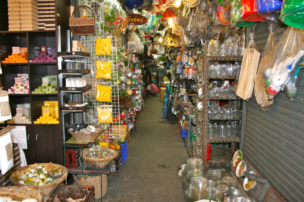 A covered market lane with household goods, glassware and baskets