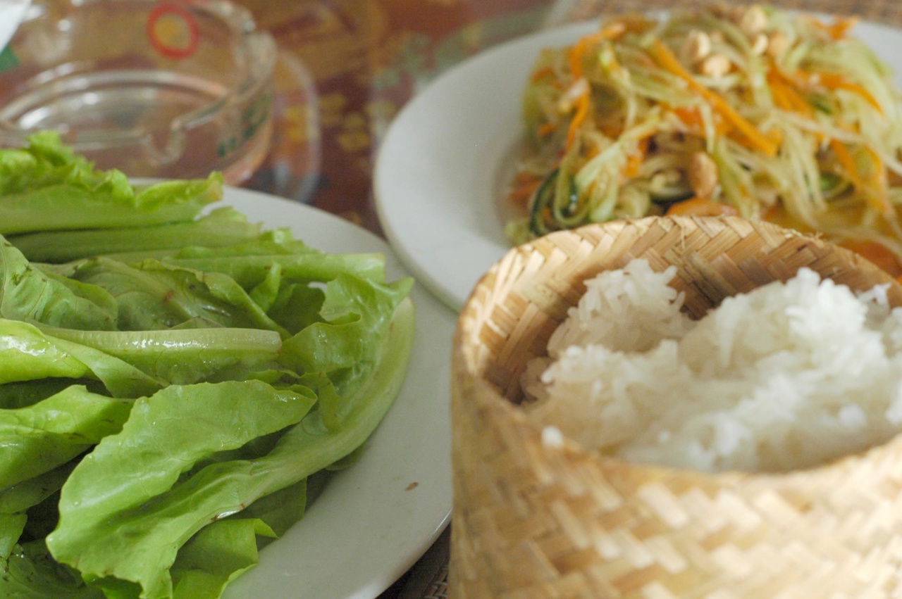 Sticky rice in its basket with papaya salad