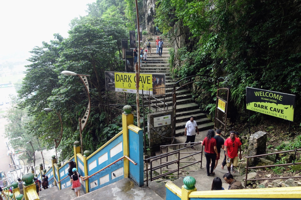 Der Weg zur Dark Cave in den Batu-Höhlen mit Hinweisschildern am Beginn der Treppe
