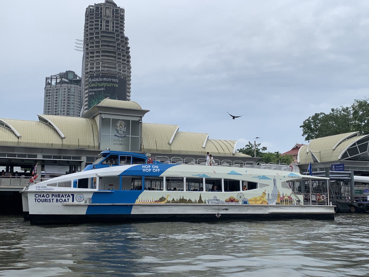 A boat arriving at Sathorn Pier on the Chao Phraya River