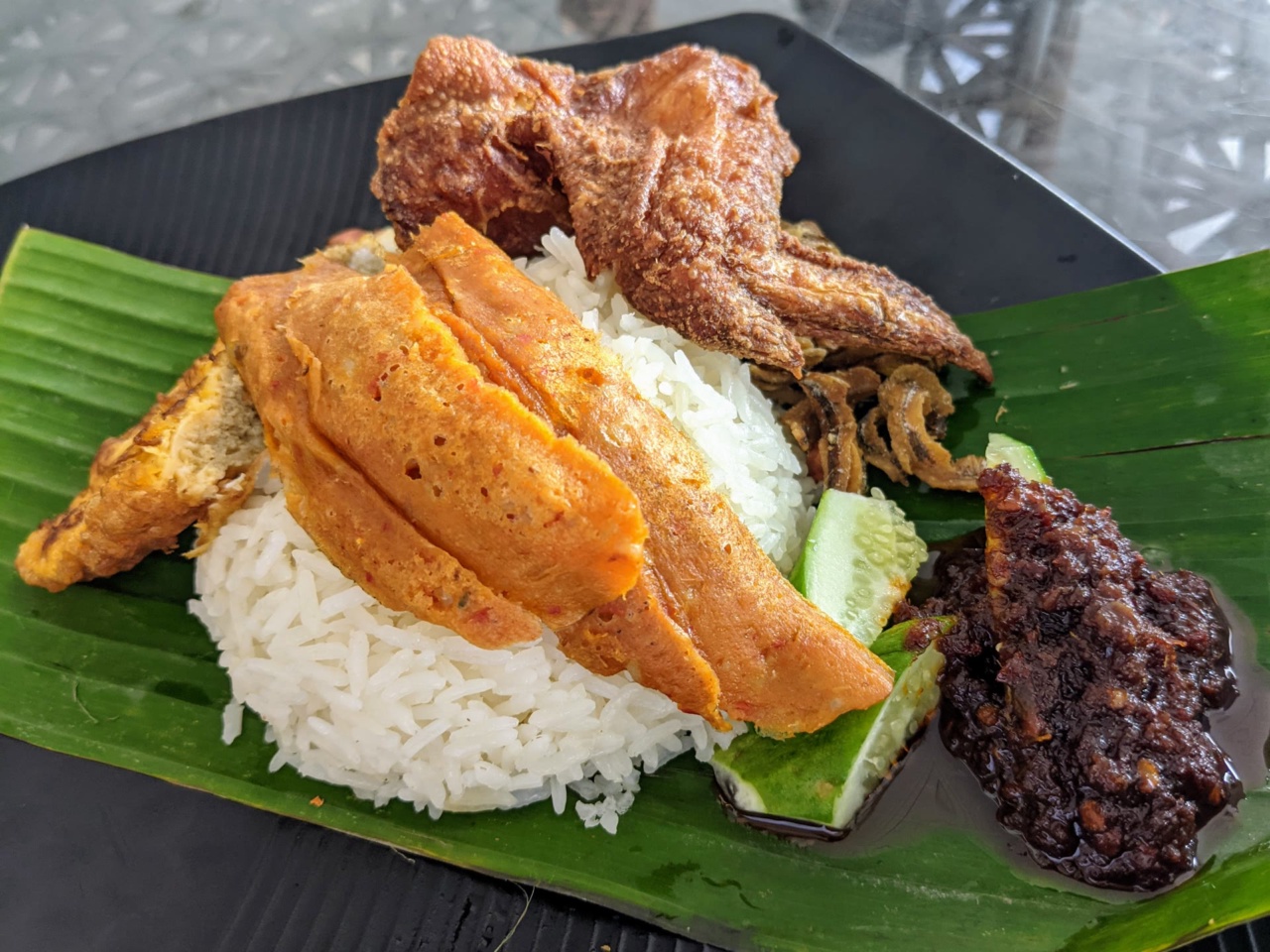 Nasi lemak dengan lauk yang disajikan di atas daun pisang