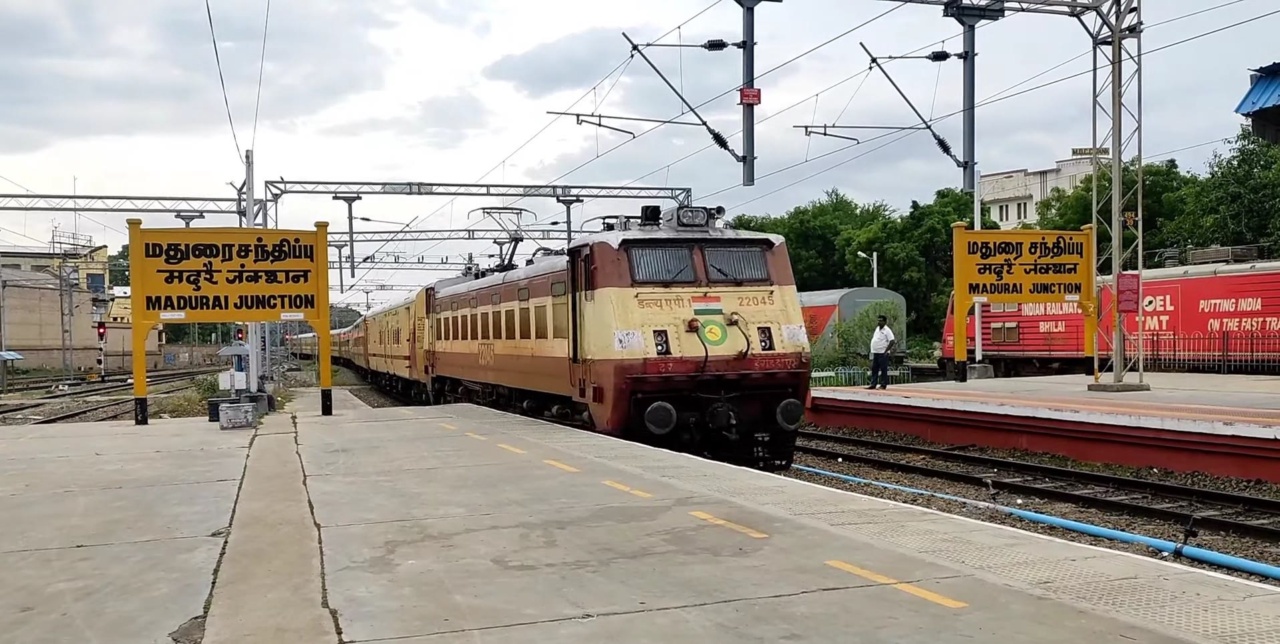 Bahnsteig im Bahnhof Madurai Junction mit Namensschild und einfahrendem Zug