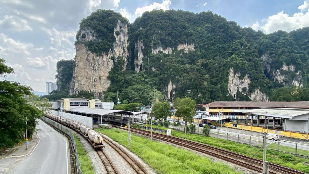 Der Bahnhof Batu Caves mit den Kalksteinfelsen hinter den Gleisen