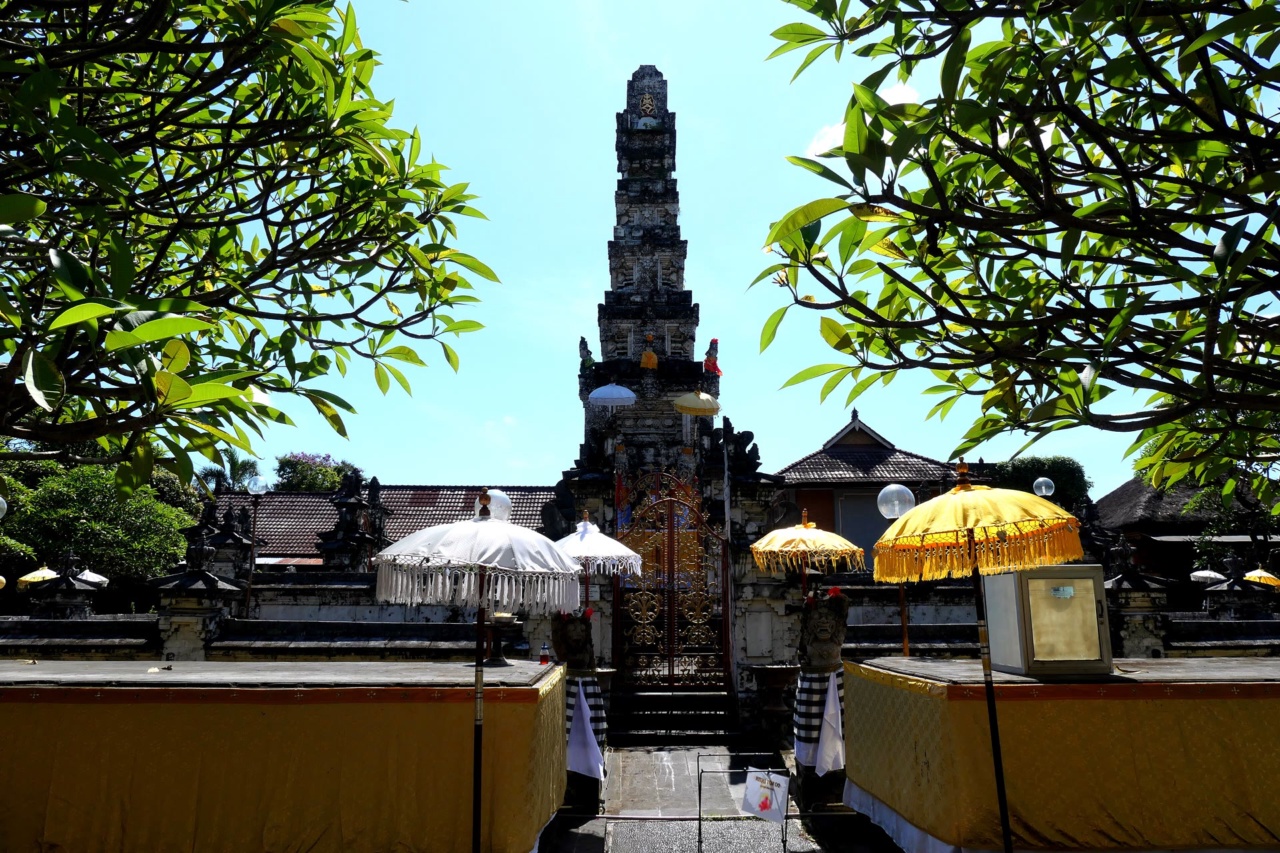 供物台と傘の奥にそびえるジャガナータ寺院の高い祠