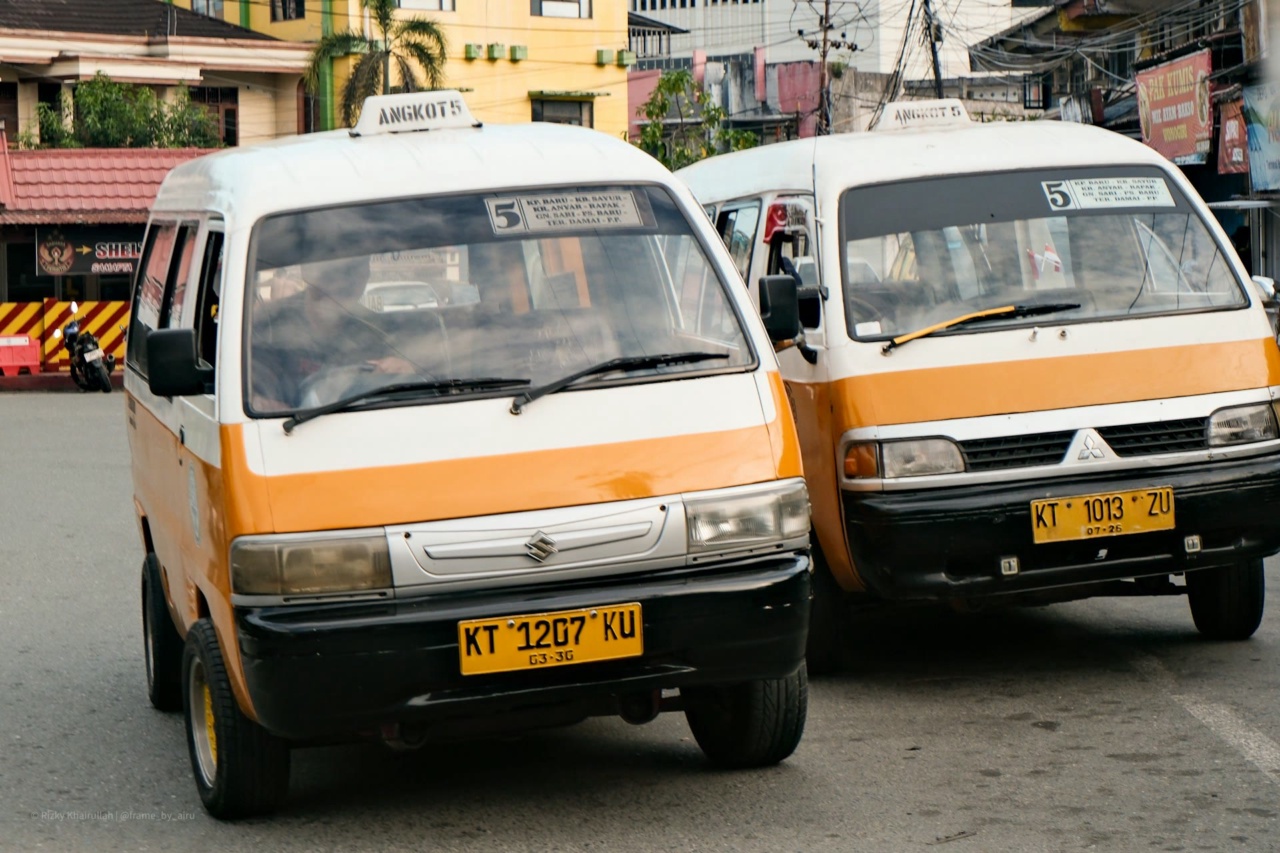 Minivan angkot oren di sebuah jalan di Indonesia