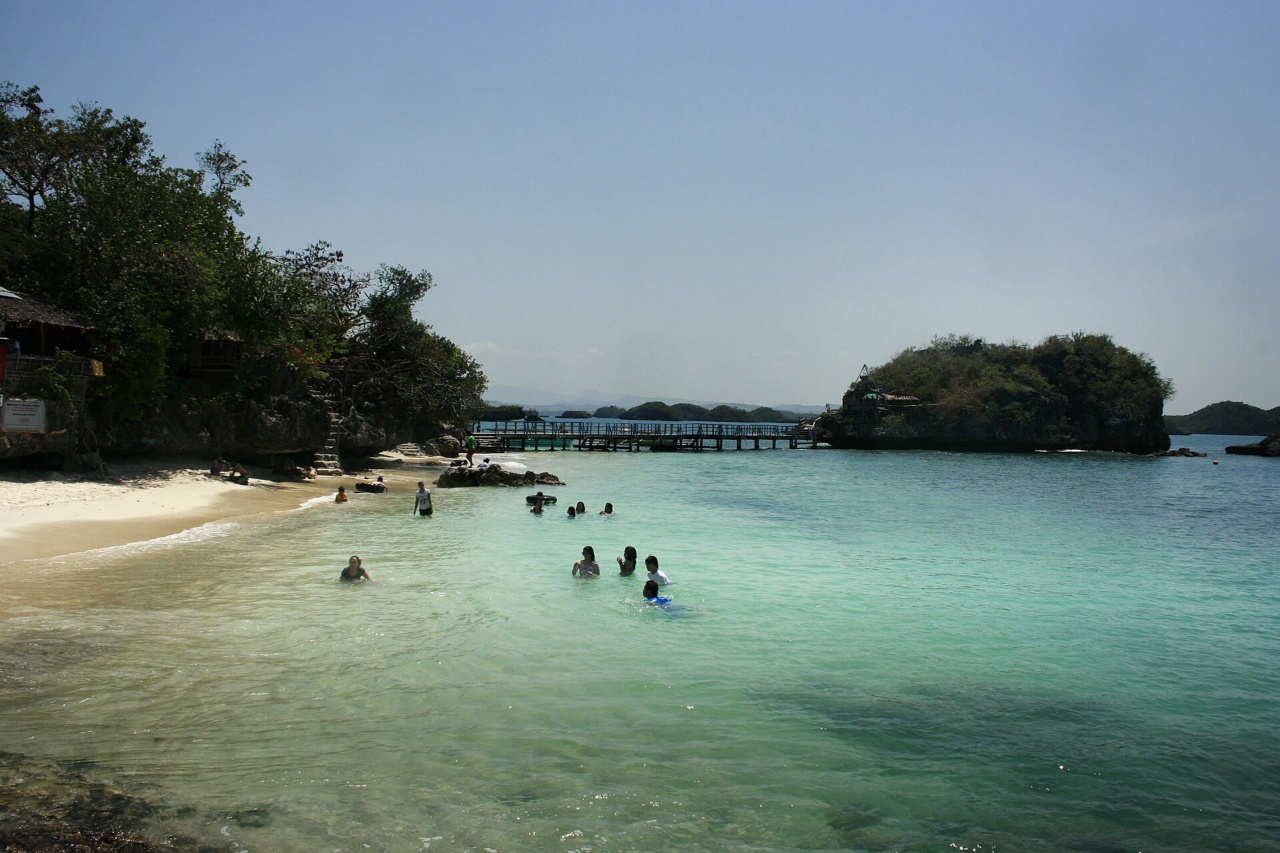 Der Sandstrand der Quezon-Insel mit Schwimmern im klaren Wasser